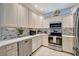 Bright kitchen featuring white cabinets, stainless steel appliances, and a tile backsplash at 6642 Willowshire Way, Bradenton, FL 34212