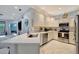 Bright kitchen featuring stainless steel appliances, white cabinetry, and mosaic backsplash, perfect for cooking and entertaining at 6642 Willowshire Way, Bradenton, FL 34212