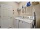 Functional laundry room with modern appliances, shelving for storage, and a door for easy access at 6642 Willowshire Way, Bradenton, FL 34212