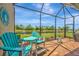 Picture of the screened in patio with two chairs and a table overlooking a lake at 6642 Willowshire Way, Bradenton, FL 34212