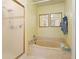 Bright bathroom featuring a soaking tub with tile surround and a glass-enclosed shower at 6780 Schooner Bay Cir # 6780, Sarasota, FL 34231