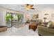 Bright living room with tile floors, ceiling fan, and sliding glass doors to the patio at 6780 Schooner Bay Cir # 6780, Sarasota, FL 34231