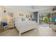 Bright main bedroom featuring tile floors, a king-size bed, and access to a screened-in lanai at 6780 Schooner Bay Cir # 6780, Sarasota, FL 34231