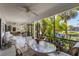 Enclosed patio features a glass table, seating, and views of the lush green landscaping at 6780 Schooner Bay Cir # 6780, Sarasota, FL 34231