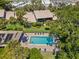 Aerial view of the community pool surrounded by mature trees and green landscaping at 6780 Schooner Bay Cir # 6780, Sarasota, FL 34231