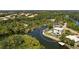 Aerial view of a yellow waterfront home with a private pool and lush landscaping at 6802 68Th E Ave, Bradenton, FL 34203
