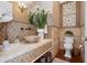 Elegant half bath with a stone vessel sink, decorative tile, and stylish wall art at 6802 68Th E Ave, Bradenton, FL 34203