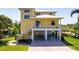 Bright yellow raised stilt home featuring covered parking and a charming front porch at 6802 68Th E Ave, Bradenton, FL 34203