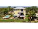 Charming yellow two-story home with balconies, lush landscaping, and a private pool at 6802 68Th E Ave, Bradenton, FL 34203