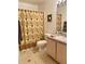 Bathroom featuring a vanity and toilet, decorated with a decorative palm tree themed shower curtain at 7411 Vista Way # 102, Bradenton, FL 34202