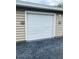 A well maintained single-car garage door with a clean, white finish and black asphalt driveway at 7411 Vista Way # 102, Bradenton, FL 34202