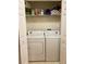 Laundry area with a white washer and dryer and wire shelves for storage at 7411 Vista Way # 102, Bradenton, FL 34202