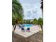 Beautiful pool and sunbathing area surrounded by lush green palm trees at 7411 Vista Way # 102, Bradenton, FL 34202