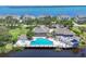 Aerial view of a community pool with lounge seating and a nearby body of water at 79 Tidy Island Blvd, Bradenton, FL 34210