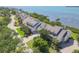 View of a long row of waterfront homes with well-manicured lawns, mature trees, and water views at 79 Tidy Island Blvd, Bradenton, FL 34210