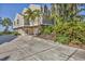 Spacious home featuring a large driveway and lush tropical landscaping at 79 Tidy Island Blvd, Bradenton, FL 34210