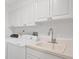 Convenient laundry room featuring a washer, dryer, utility sink, and ample cabinet space at 79 Tidy Island Blvd, Bradenton, FL 34210