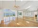 Bright living room features hardwood flooring, a wall mirror, and expansive windows with water views at 79 Tidy Island Blvd, Bradenton, FL 34210