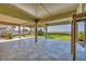 Large covered patio with stone tile flooring and pillars overlooking the waterfront at 79 Tidy Island Blvd, Bradenton, FL 34210