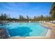 Large community pool perfect for relaxation and recreation, surrounded by lush landscaping and clear skies at 79 Tidy Island Blvd, Bradenton, FL 34210