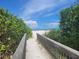 Wooden boardwalk leading to a picturesque beach under a blue sky at 845 Benjamin Franklin Dr # 101, Sarasota, FL 34236