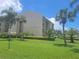 Exterior view of building with well-manicured lawns and palm trees in the front at 845 Benjamin Franklin Dr # 101, Sarasota, FL 34236