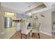 Charming dining area with a glass table, chandelier, and modern kitchen in the background at 845 Benjamin Franklin Dr # 101, Sarasota, FL 34236