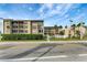 Beautiful building exterior featuring balconies, palm trees and well-kept landscaping at 845 Benjamin Franklin Dr # 101, Sarasota, FL 34236