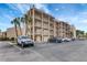 Condo exterior elevation with palm trees and multiple cars parked in a lot at 845 Benjamin Franklin Dr # 101, Sarasota, FL 34236