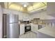 Well-lit kitchen with white cabinets, stainless steel appliances, and tile flooring at 845 Benjamin Franklin Dr # 101, Sarasota, FL 34236