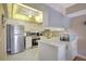 Modern kitchen features stainless steel appliances, white cabinets and unique ceiling lighting at 845 Benjamin Franklin Dr # 101, Sarasota, FL 34236