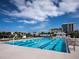 Large swimming pool with lane markers, surrounded by lounge chairs and nearby buildings at 845 Benjamin Franklin Dr # 101, Sarasota, FL 34236