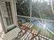 Screened balcony with a table and chairs overlooking the lush landscaping and water at 850 S Tamiami Trl # 529, Sarasota, FL 34236