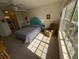 Sunlit bedroom featuring a ceiling fan, a cozy chair, and a large window with natural light at 850 S Tamiami Trl # 529, Sarasota, FL 34236