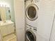 Convenient laundry area featuring a stacked washer and dryer unit with a vanity in the adjacent bathroom at 850 S Tamiami Trl # 529, Sarasota, FL 34236