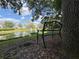 Lakeside bench under a shady tree offers a serene spot to unwind and enjoy picturesque water views at 850 S Tamiami Trl # 529, Sarasota, FL 34236