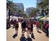 A lively downtown street scene shows people walking between tents and buildings under palm trees on a sunny day at 850 S Tamiami Trl # 529, Sarasota, FL 34236