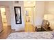 Light bedroom featuring wood floors, a chair, a bedside table, and a mirror, leading to a bathroom at 850 S Tamiami Trl # 704, Sarasota, FL 34236