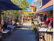 Vibrant outdoor dining scene with restaurants, flowers, and sunny ambiance, showcasing community at 850 S Tamiami Trl # 704, Sarasota, FL 34236