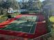 Overhead view of a pickleball court with green and red coloring, surrounded by shrubbery at 850 S Tamiami Trl # 704, Sarasota, FL 34236