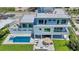 Expansive backyard featuring a pool and spa, outdoor kitchen, and stylish patio furniture at 8800 Midnight Pass Rd, Sarasota, FL 34242