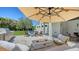 Outdoor kitchen and lounge area including a grill, fire pit, and an umbrella with a large in-ground swimming pool at 8800 Midnight Pass Rd, Sarasota, FL 34242