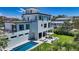Beautiful backyard with a modern pool, patio with seating, and lush landscaping of a modern home at 8800 Midnight Pass Rd, Sarasota, FL 34242