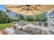 Outdoor kitchen and lounge area including a grill, fire pit, and an umbrella with a lovely green space at 8800 Midnight Pass Rd, Sarasota, FL 34242