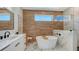 Modern bathroom with white soaking tub, wood accent wall, and a glass-enclosed shower with marble surround at 8800 Midnight Pass Rd, Sarasota, FL 34242