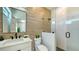 Bathroom featuring brown tiles, black hardware, a glass enclosed shower, and a bright vanity at 8800 Midnight Pass Rd, Sarasota, FL 34242