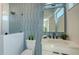 Modern bathroom featuring blue tiles, black hardware, a glass enclosed shower, and a bright vanity at 8800 Midnight Pass Rd, Sarasota, FL 34242
