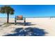 Welcome to Siesta Beach! A sign in the sand with clear blue skies at 8800 Midnight Pass Rd, Sarasota, FL 34242