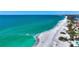 Beautiful aerial view of the turquoise ocean meeting a bright sandy beach on a sunny day at 8800 Midnight Pass Rd, Sarasota, FL 34242