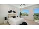 Bedroom featuring a queen bed, light hardwood flooring, balcony access, and decor accents at 8800 Midnight Pass Rd, Sarasota, FL 34242